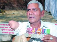 A handicapped ex-serviceman returns his medals at Jantar Mantar in New Delhi
