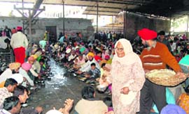 Pilgrims at the Guru Ram Rai Darbar Sahib have langar on the eve of Jhanda Mela in Dehradun
