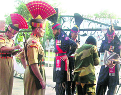 BSF men and Pakistan Rangers exchange newspapers at the Attari-Wagah border  check post on Thursday.