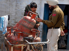 A cop questioning an LPG cylinder vendor of a gas agency, who is accused of stealing gas from the cylinders, in Bathinda on Sunday.
