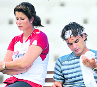 Switzerland's Roger Federer takes a break next to his girlfriend, Mirka Vavrinec, during a tennis practice session ahead of the Beijing 2008 Olympic Games in this August 7, 2008 file photo.