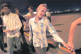 Doctors Without Borders Laura Archer of Canada (right), Mauro DAscanio of Italy (left) and Raphael Meunier of France (center background) are escorted after their release from captivity in Darfur, at Karthoum airport, Sudan
