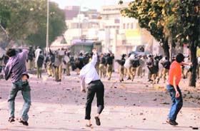 Protesters throw stones at the police during a countrywide anti-government protest march in Lahore