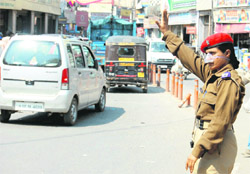 A woman Home Guard regulates traffic in Dehradun.