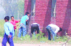 Friends of examinees pass slips inside an examination centre at Baupur village in Shahkot on Monday.
