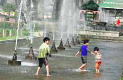 Children frolic in water at Nishat Garden on the outskirts of Srinagar on Monday.