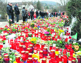 Mourners stand in front of flowers and candles in Winnenden, south Germany on Sunday. A 17-year-old gunman and former pupil of Albertville High School killed 15 people before he turned the gun on himself on Wednesday