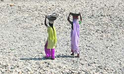 Women walk on the dry bed of the Song river near Dehradun. 