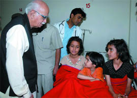 BJP prime ministerial candidate L.K. Advani meets daughters of the family that tried to commit suicide on Wednesday, at Bhagwan Mahavir Hospital in New Delhi on Saturday.