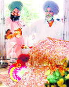 Devotees offer liquor as prasad at the samadh of Baba Rode Shah at Bhoma village on Saturday.