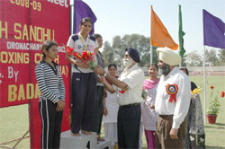 Gurbax Singh Sandhu, boxing coach and Dronacharya Awardee, giving away prize to a winner of the annual athletic meet organised at Dasmesh College of Education, Badal, on Saturday.