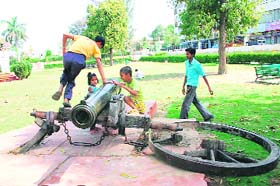Kids play on a damaged cannon in the Mansarovar Park in Rohtak