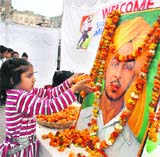 A child pays floral tributes to Shaheed Bhagat Singh on his 78th Martyrdom Day in Jammu on Monday. 