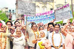 Members of the J&K Refugee Front protest in front of the Divisional Commissioner office at Mubarak Mandi in Jammu