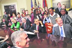 President Barack Obama, accompanied by members of the Congress and schoolchildren, talks to astronauts on the International Space Station on Tuesday from the Roosevelt Room of the White House in Washington.