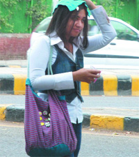 A girl uses her hanky to save herself from rain in New Delhi on Friday.