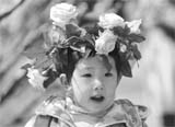 A girl wear flowers in their hair at a park in Beijing on Saturday. Locals flocked to parks and gardens to enjoy the blooming flowers in the warm spring weather.