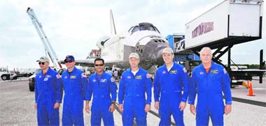 The crew of space shuttle Discovery. From left, commander Lee Archambault, pilot Tony Antonelli, and mission specialists Joseph Acaba, Steve Swanson, Richard Arnold, and John Phillips, stand in front of the orbiter after landing at Kennedy Space Centre in Cape Canaveral