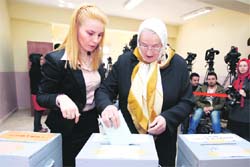 A woman casts her vote during local elections at a voting centre in Istanbul