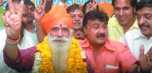 BJPs North East candidate B.L. Sharma flashes a victory sign during a campaign in East Delhi on Monday.