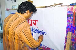 A local painter paints a banner