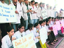 Students of Dr R.P. Government Medical College, Tanda, holding a mute protest carrying placards and wearing black badges against the magisterial inquiry report which had probed the ragging incident and indicted principal Dr Suresh Sankhyan. 