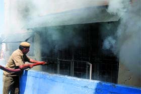 Police personnel douse fire that engulfed a saree showroom at Chandni Chowk in New Delhi