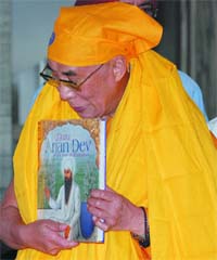 Spiritual leader Dalai Lama with a book on Guru Arjan Dev presented to him by the Rakab Ganj Gurudwara