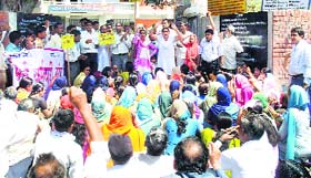 Activists of social organisations hold a protest outside a police station in Bhiwani
