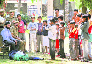 Security officials punish children for playing inside the Jammu University campus without permission on Tuesday.