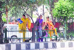 Three girls jump over the railing to cross over to the other side of the road outside Gandhi Nagar Government College for Women in Jammu. 