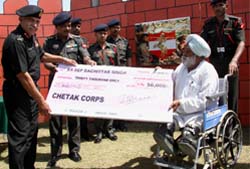 Lt-General D.S. Chauhan, GOC, Chetak Corps, presenting financial assistance to ex-sepoy Bachitter Singh at the Bathinda military station 