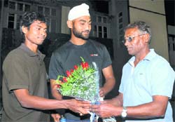 Former Olympian Ashok Dhyanchand (R) hands over a bouquet to senior national hockey team captain Sandeep Singh (C) and senior player Dilip Tirkey as they leave for Sultan Azlan Shah Hockey Tournament, in Bhopal 