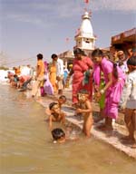 On the concluding day of the three-day religious fair, a mother gives her child a holy dip in the sarovar at Maisar Khana in Bathinda on Thursday.