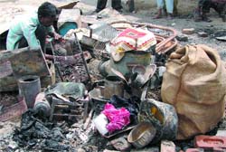A man looks for his belongings in ashes at Bhalaswa where 300 jhuggis were destroyed in a fire 