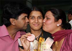 Proud parents of Diksha kiss her after she romped home with a bronze from the National Boxing Championship, in Bathinda on Friday. 