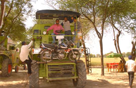 Farmers on their way back from Gujarat enter Bathinda on a combine harvester.