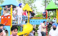 Workers of the Congress climb atop swings to catch a glimpse of the press briefing by Capt Amarinder Singh at Chandigarh Press Club
