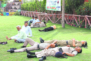 Policemen enjoy a seista in a park in Dehradun on Sunday, even as political leaders with whom they are attached hold an election meeting.