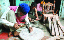 Artisans engaged in an imitation ivory inlay work at a workshop in Hoshiarpur.