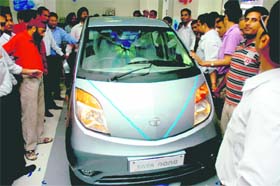 People have a close look at Tata Nano on display in Jammu