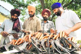 As the harvesting season begins, farmers take a look at traditional sickles at the Pakhowal road in Ludhiana