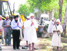 Granthis of Gurudwara Karamsar, Rara Sahib, pray at a village near Ahmedgarh before uprooting the stumps