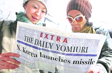 A man and a woman read a newspapers extra edition following a North Korean rocket launch in Tokyo on Sunday. The launch drew swift international condemnation.  Reuters