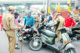 Cops check documents of two-wheelers in Jammu on Monday.