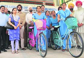 Women health visitors being given bicycles to carry out healthcare services in Hambran