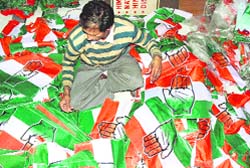 A Congress worker prepares party flags for use during the election campaign, at the partys office in Shimla