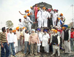 Members of the various Sikh organisations staging protest on the railway track at Ferozepur on Wednesday.