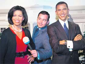 ALL SMILES: A reporter does a TV spot at Madame Tussauds Wax Museum in Washington DC on Tuesday with the likenesses of US President Barack Obama and his wife Michelle Obama