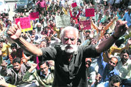 Members of the PHE Workers Welfare Association hold a protest in Jammu on Thursday